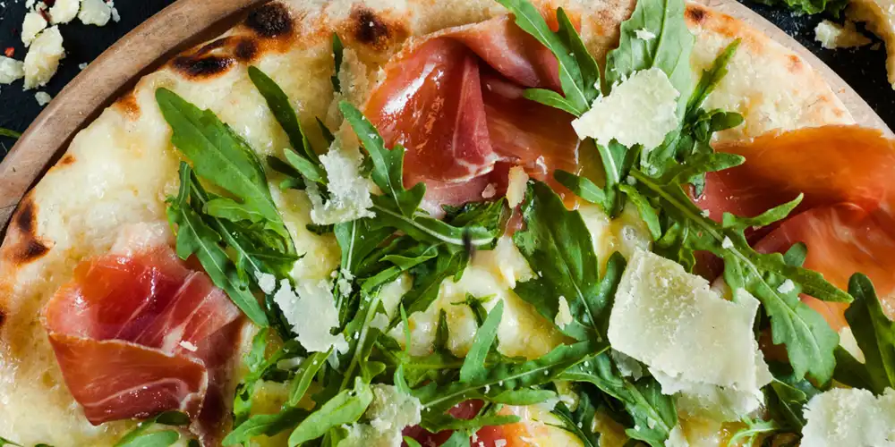 Pizza with procuito, arugula and parmesan